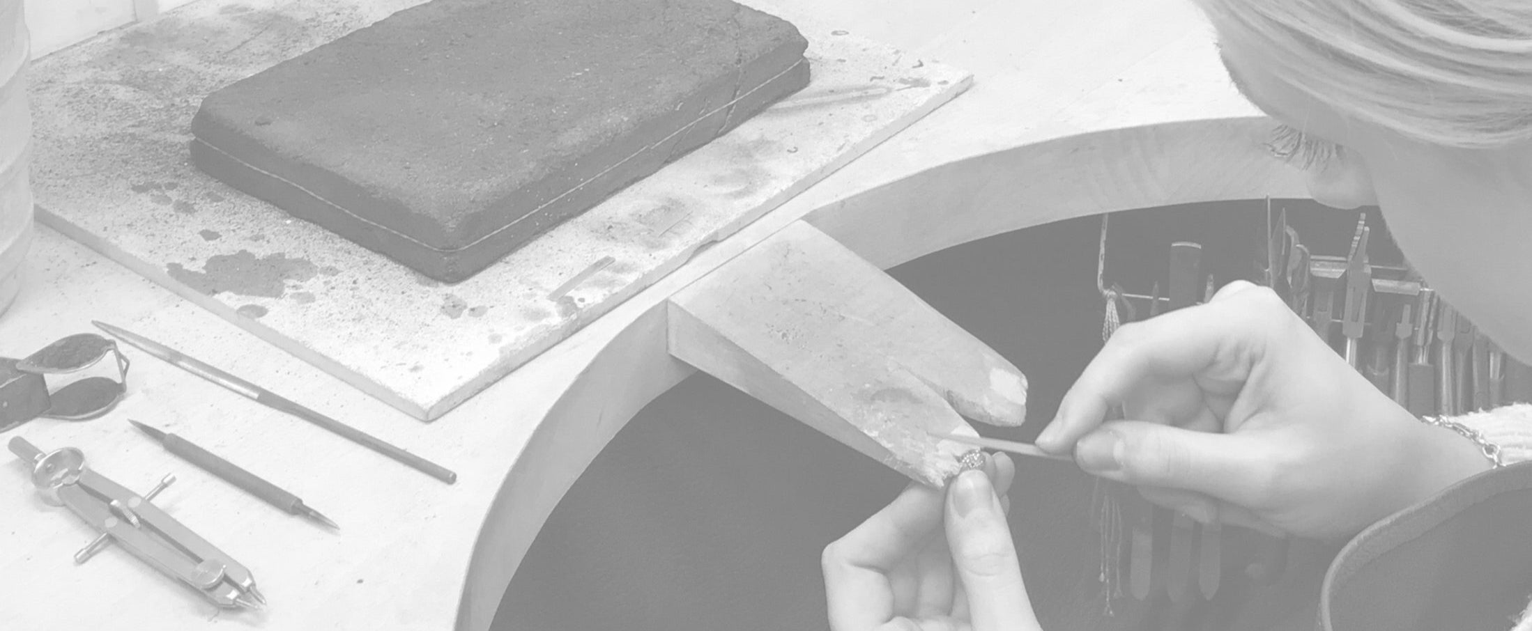 Person working on a craft project with tools and materials on a table.